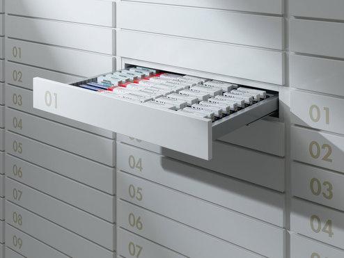 Detailaufnahme von Medikamentenschubläden Detailaufnahme von schmalen weißen Medikamentenschubläden mit dezenter Nummerierung und sichtbarer Medikamentenaufteilungen.